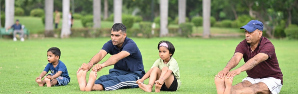 Image of two children and two adults stretching in a park